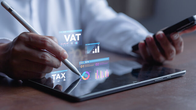 vat, tax, taxation, taxes, finance.Professional using a tablet and smartphone to manage VAT and tax analytics dashboards, showcasing digital compliance, financial reporting and accounting technology.