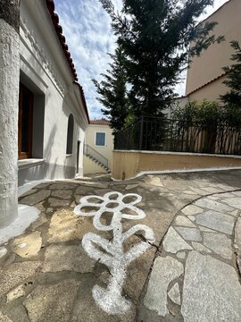 White flower drawing along a stone path in a quiet outdoor area under a cloudy sky in early afternoon