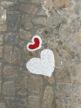 Hearts painted on cobblestone street in a city during daylight