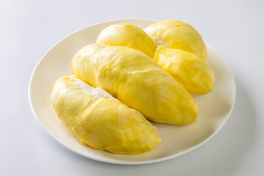 Durian the king of fruit in Thailand. Pulp of fresh Durian yellow color on dish isolated on white desk background
