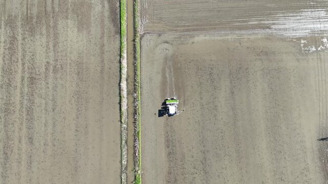 Rice Transplanter Working in Flooded Paddy Field, Top Down Drone View