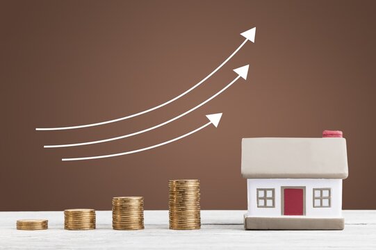 House Model with Golden Coins Stacks on the desk