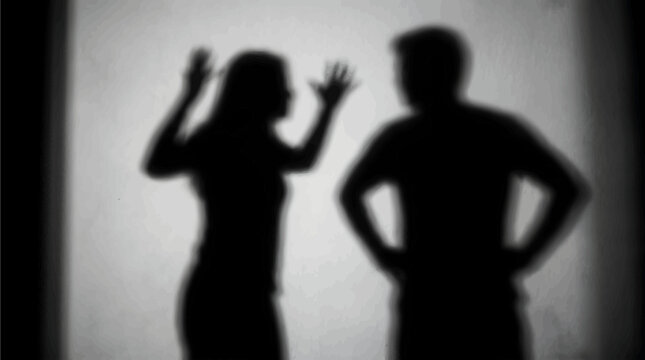 Stark black and white shadow of couple arguing aggressively with hands raised in anger on smooth wall surface
