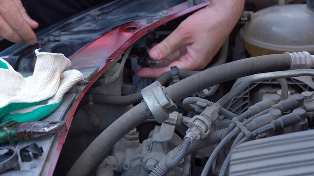 Detailed Close-Up of Automotive Repair Process: A Mechanic's Hands Working on Engine Components to Ensure Optimal Vehicle Performance and Maintenance