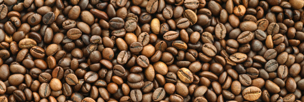 Detailed view on brown roasted coffee beans in big pile on table close up