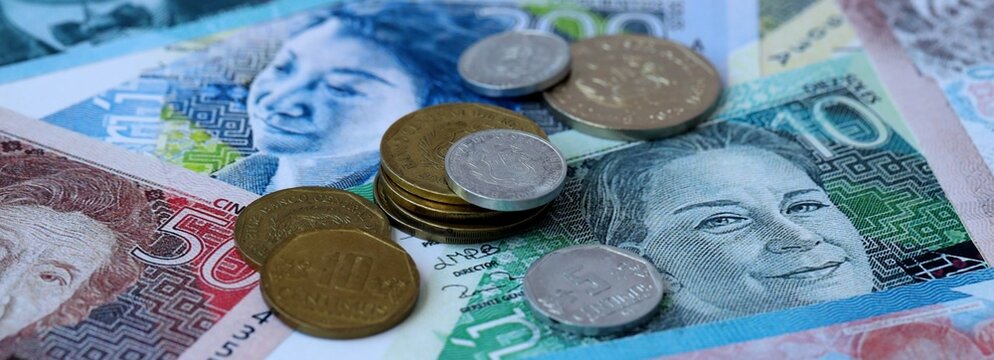 Peruvian sol money banknotes and coins on table. Peru cash bills of PEN currency