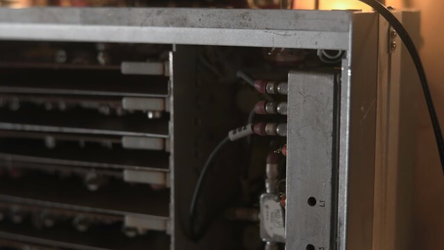 Power Supply Inspection. Detailed Examination Of Power Supply Unit Under Warm Lighting Conditions. Media