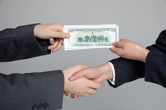 Handshake with cash exchange symbolizing bribery and business corruption