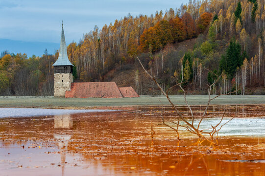 Church tower rising from the toxic tailings lake of Geamana, flooded by mining waste from Roșia Poieni copper mine, Apuseni Mountains, Romania. 