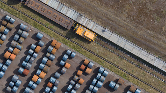 Aerial view of Tata Steel industrial facility with rows of steel coils and a yellow locomotive on tracks Velsen-Noord, Noord-Holland, Netherlands.