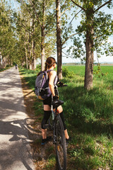 Obraz premium Active woman enjoying outdoor wellness lifestyle through cycling in countryside.