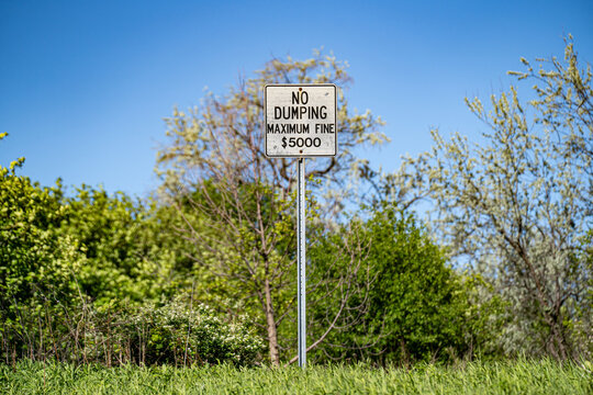 No dumping warning sign with maximum fine notice.