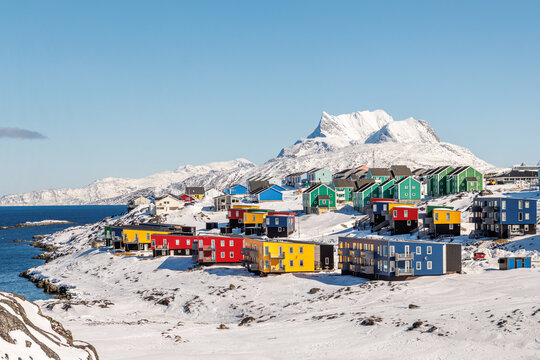 Arctic residential landscape with modern colorful Greenlandic houses, sea coast, winter snow and Sermitsiaq mountain, Nuuk, Sermersooq, Greenland