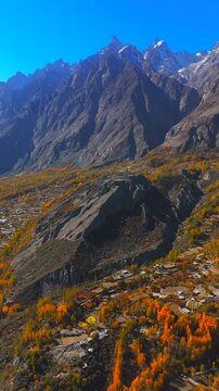 Aerial view of Gulmit village with autumn foliage and Karakoram mountains in Hunza Nagar, Gilgit Baltistan, Pakistan.
