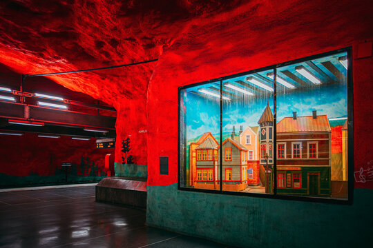 Solna Centrum metro station with red walls and painted mural of houses, Stockholm