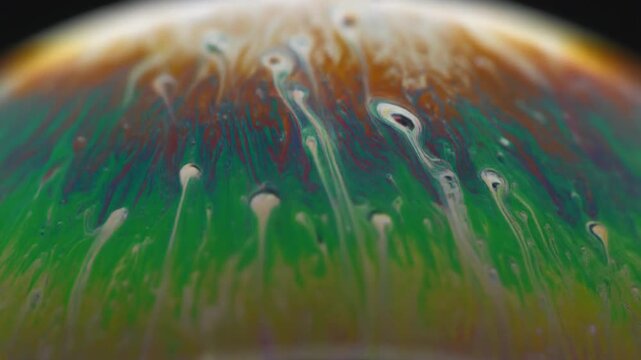 Abstract colorful swirling pattern. Vibrant purple, green, and yellow fluid motion. Seamless looping background texture for creative projects and presentations.