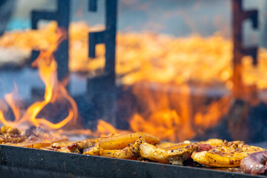 A captivating, close-up commercial shot of seasoned pork belly steaks sizzling on a hot flat-top grill surface.