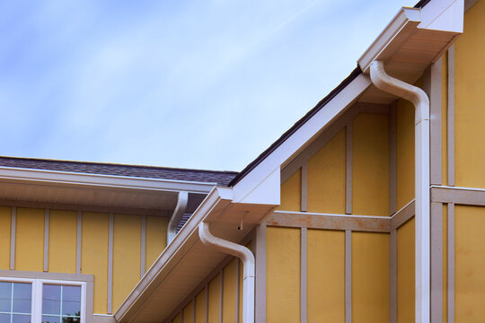 Yellow Hardie siding new house rooflines, edges gutter details,