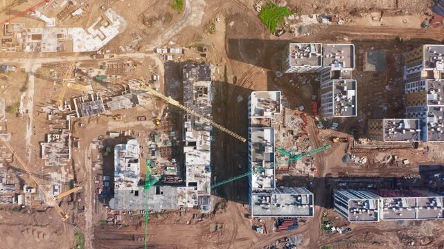 Construction progress of urban residential development with tower cranes and machinery in an active construction zone