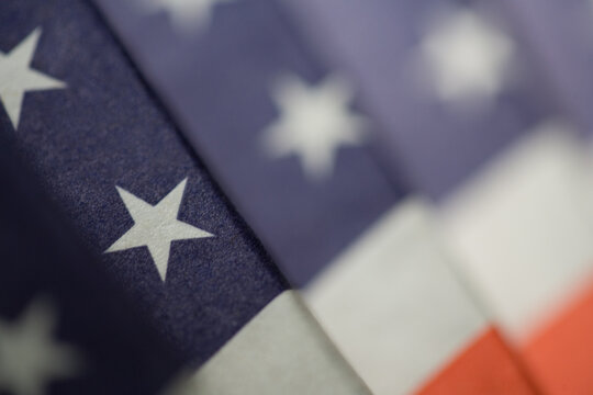 Red, white & blue close-up folded American flag fan with stripes, stars, & single star focus: background & symbol of democracy, freedom, government, veterans & United States federal holidays.