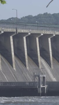 Conowingo, Maryland - May 18, 2026: the sheer scale of the massive Conowingo dam and hydroelectric station with vehicle traffic driving overhead, birds in flight, and huge outflows of water current