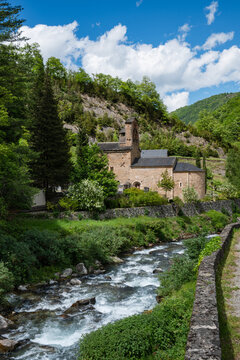 Mountain landscape with a 12th century Romanesque church and a river in the foreground. Salau Ariege Pyrenees France