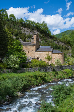 Mountain landscape with a 12th century Romanesque church and a river in the foreground. Salau Ariege Pyrenees France