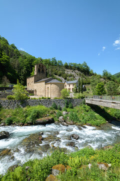 Mountain landscape with a 12th century Romanesque church and a river in the foreground. Salau Ariege Pyrenees France