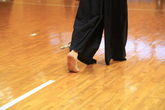 Bare foot steps lightly across polished wood floor