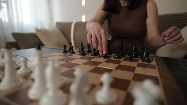 Intelligent Woman Sets Chess Pieces On A Board For A New Game, Selective Focus
