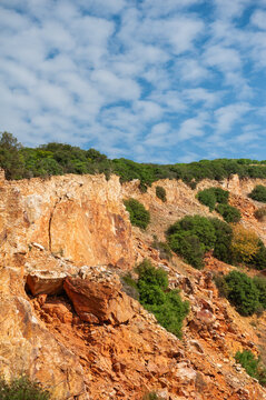 Nature background with wall of rock, blue sky and crowns of forest