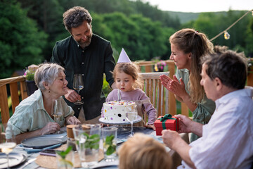 Fototapeta na wymiar Little girl blowing candle from birthday cake.