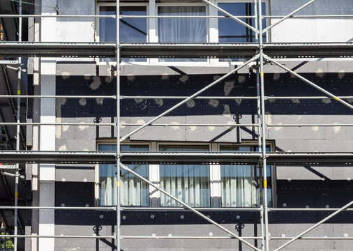 Eine einger&uuml;stete Fassade eines Mietshaus, das mit D&auml;mmplatten verkleidet wird in Wuppertal, Deutschland