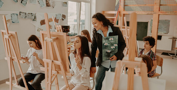 A smiling Hispanic teacher inspires diverse children in a warm naturally lit art class fostering a creative and authentic vibe