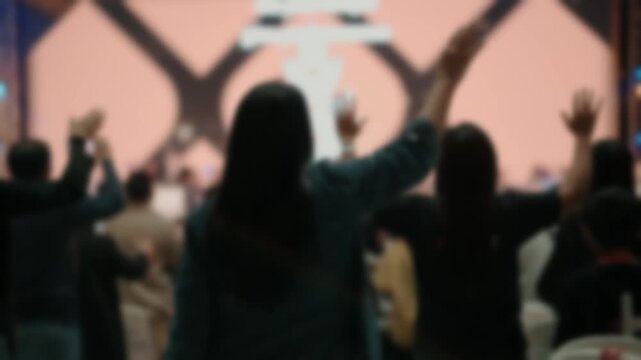 Rear view of a crowd raising hands during a live event. Concept of inspiration, hope, unity, celebration, emotional connection, participation, and community engagement.