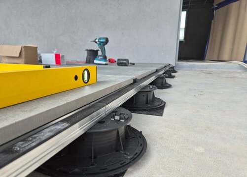 Floor level view of an access raised floor installation with adjustable pedestals and hand tools.