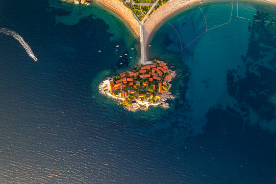 Aerial top view of Sveti Stefan island resort in Montenegro. Stunning drone shot of the famous Sveti Stefan luxury island hotel with terracotta roofs surrounded by turquoise adriatic sea, Montenegro