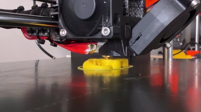 Detailed view of FDM three dimensional printer active extrusion process creating prototype inside home workshop