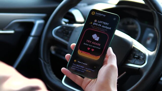 Experience the thrill and risk of mobile gambling. User plays a digital lottery in a car and receives a Try Again loss message. Perfect for documentaries on gambling addiction, financial advice, and