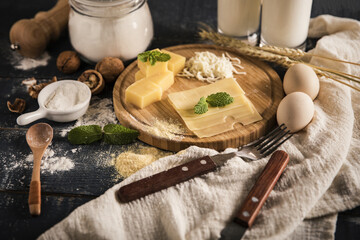Fototapeta premium Rustic cheese and baking ingredients on wooden board