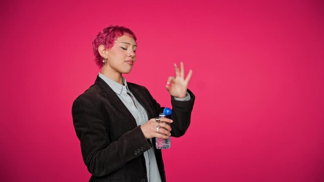 Young businesswoman drinking water and posing