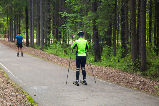 Cross Country Skiling. A man in the park runs on ski rollers.