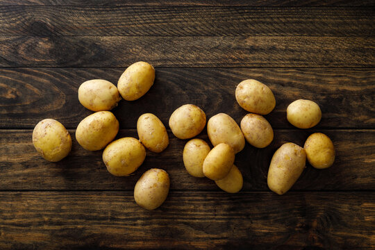 Fresh raw whole potatoes on rustic wooden table, top view