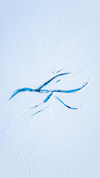 Abstract blue light streak forming a jagged lightning bolt or crack shape on a solid light blue background with lightning abstract artistic luminous fracture electric composition