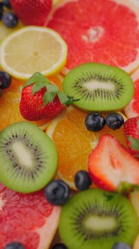 Background of fresh fruits and berries rotating. Vegan sweet food, flat lay.