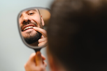 Man checking oral health looking in mirror