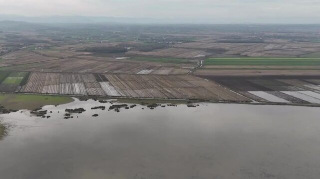 Aerial view of the Kizilirmak Delta featuring vast agricultural fields and wetlands under a cloudy sky in Bafra, Samsun, Turkiye.