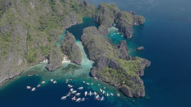 Aerial view of Big Lagoon with turquoise water, limestone cliffs and bangka boats anchored in the sea in El Nido, Mimaropa, Philippines.