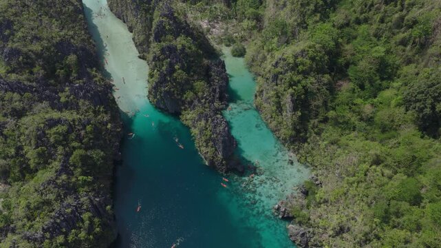 Aerial view of Big Lagoon with turquoise water surrounded by limestone cliffs and lush green vegetation in El Nido, Mimaropa, Philippines.