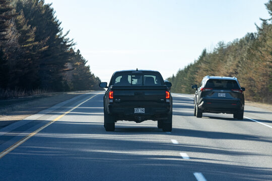 Quebec, Canada, 24 April 2026 : Black Toyota Tacoma pickup truck and dark grey Toyota RAV SUV drive on a highway.